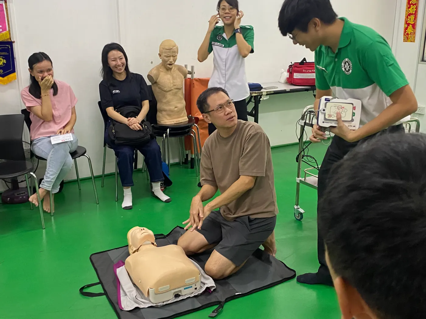 Instructor demonstrating CPR to parents and children