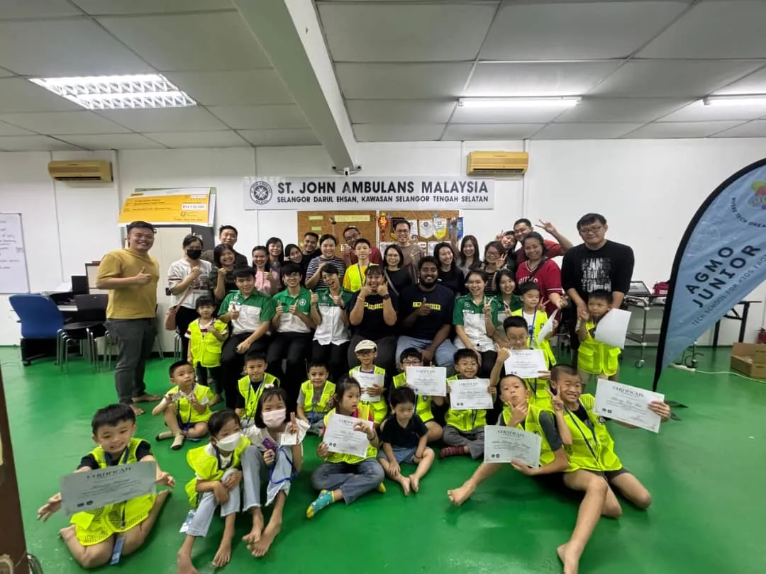 Children and adults holding certificates after the first aid session with St John Ambulance Malaysia