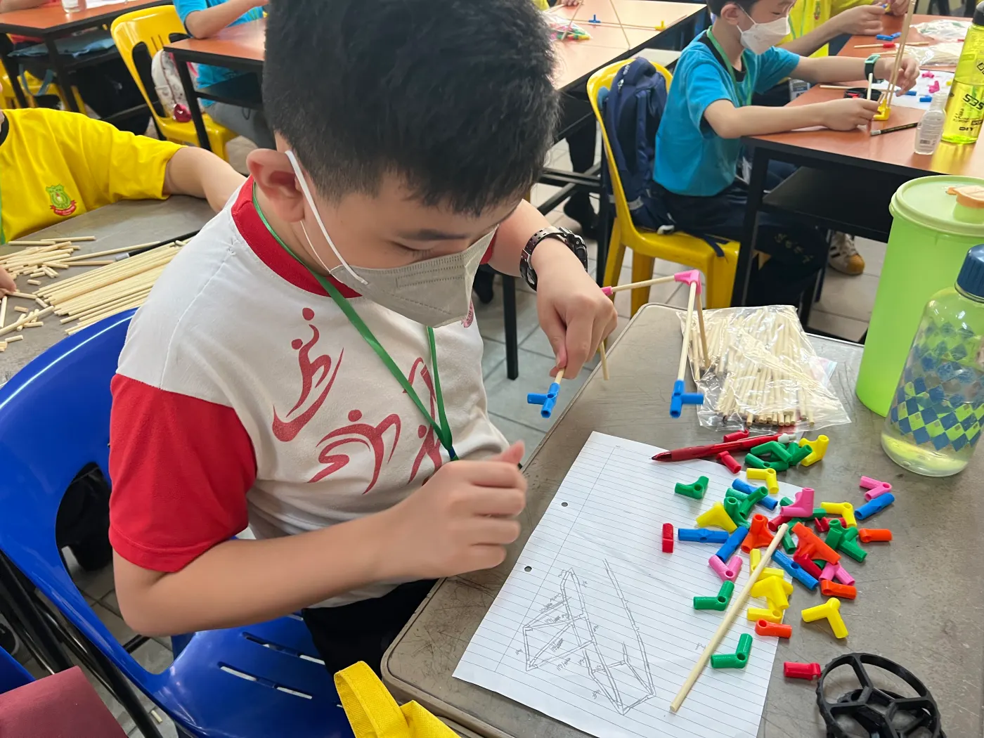 A student building a model with coloured connectors and rods