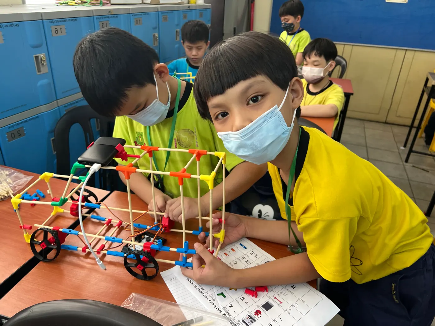 Two students with the rod-and-connector vehicle they built
