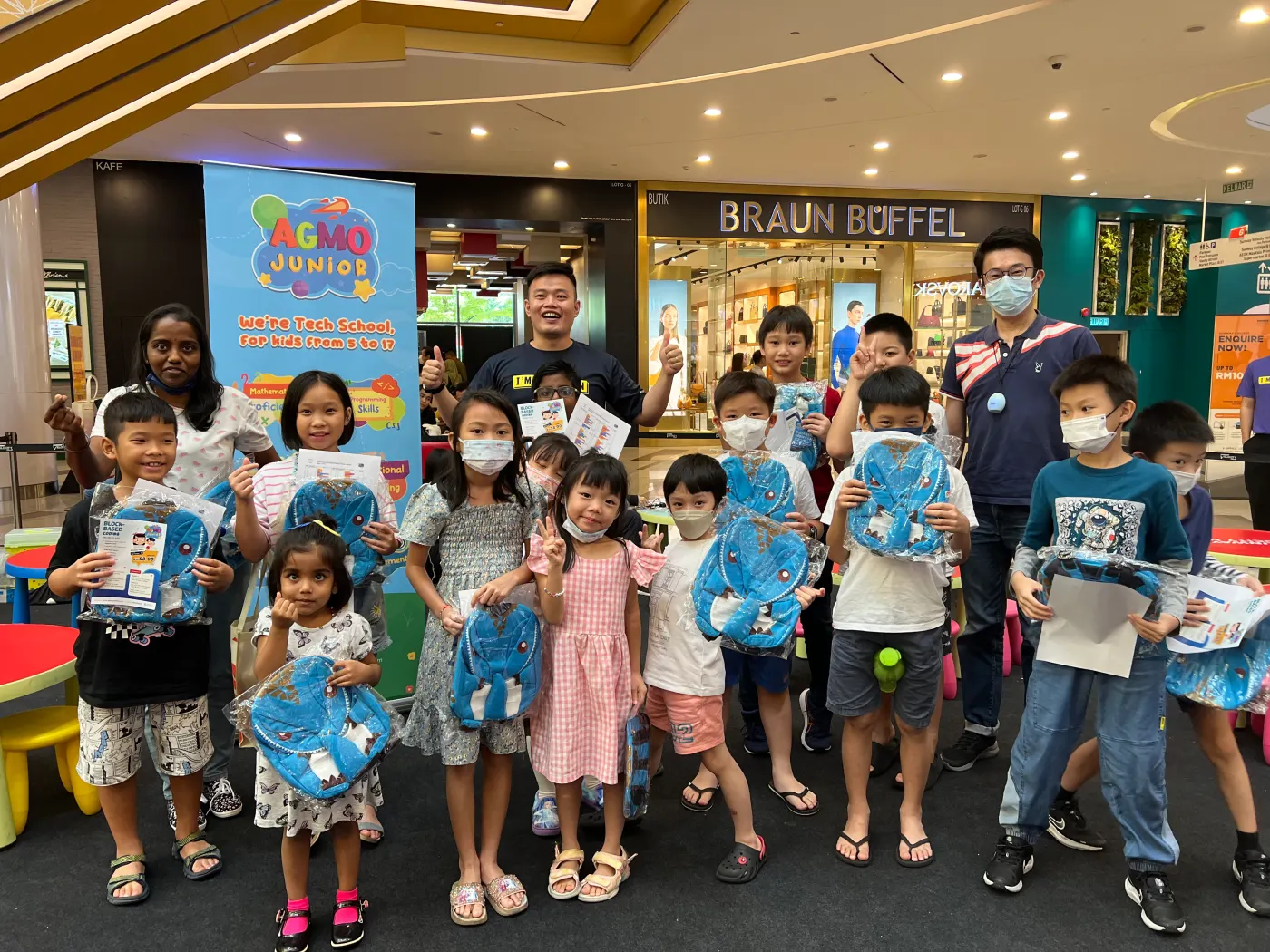 Children holding Agmo Junior bags at a community workshop in a shopping mall