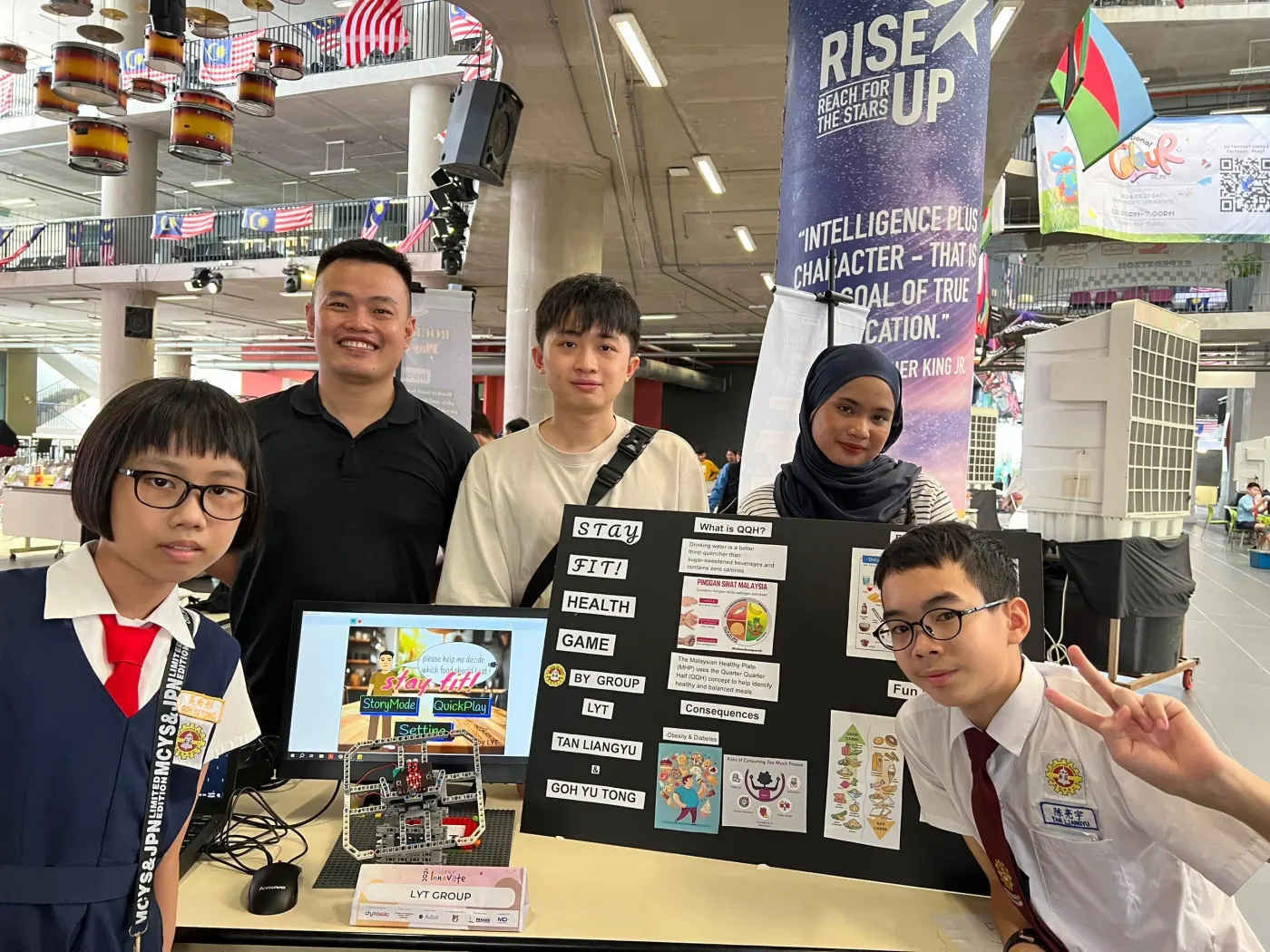 Agmo Junior students with their trainer at their project booth at the Junior Innovate State Maker Fair 2024