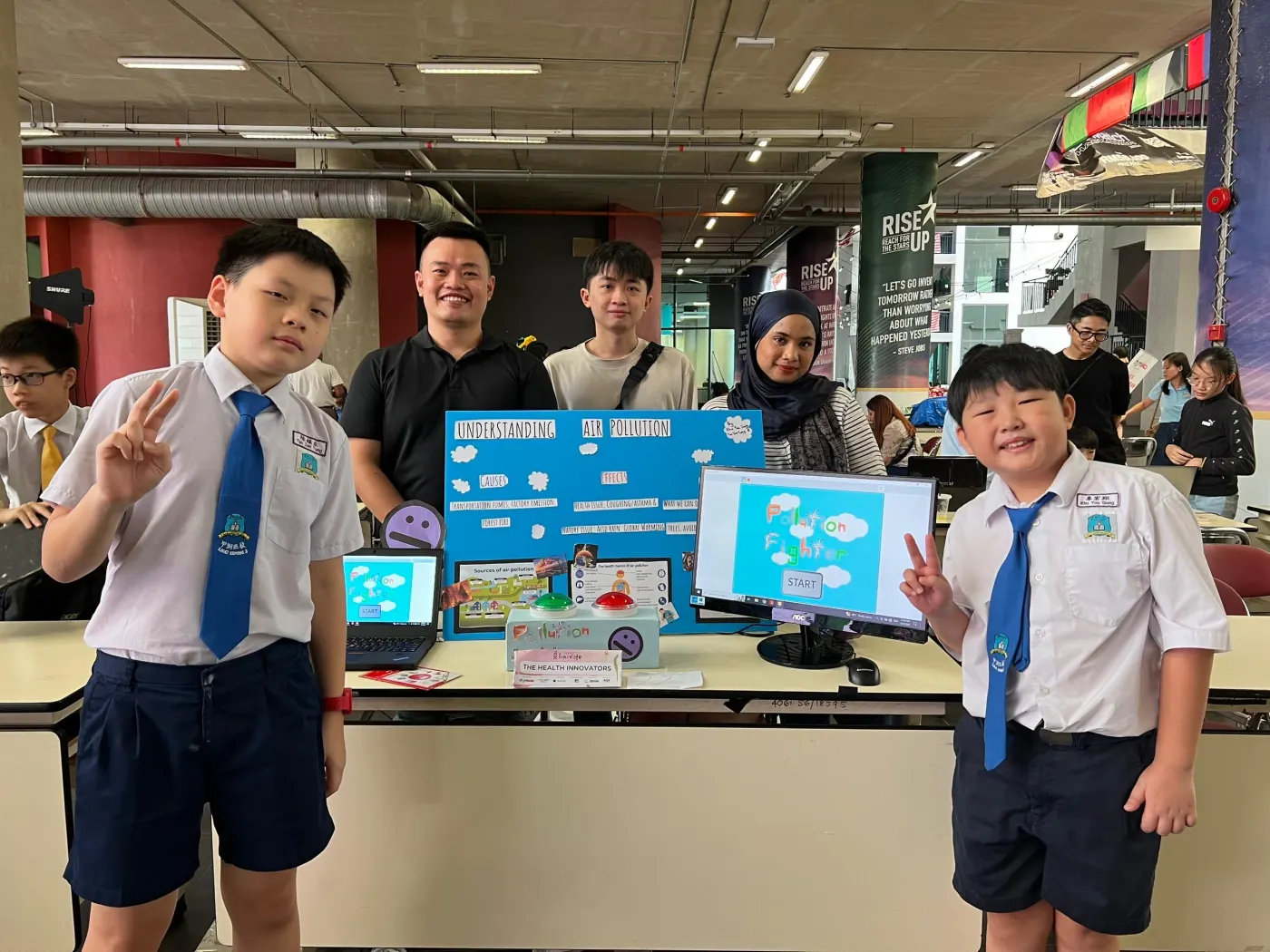 Agmo Junior students in school uniform presenting their Micro:bit arcade games at the maker fair
