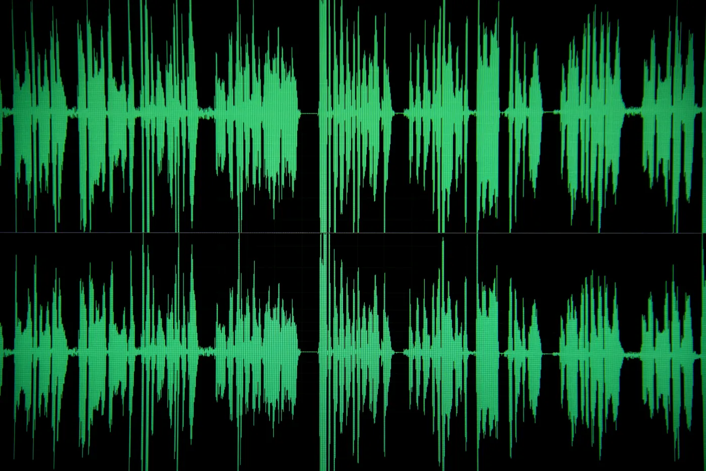 Green audio waveforms on a black background, depicting sound frequencies. The image conveys a sense of dynamic movement and rhythm.