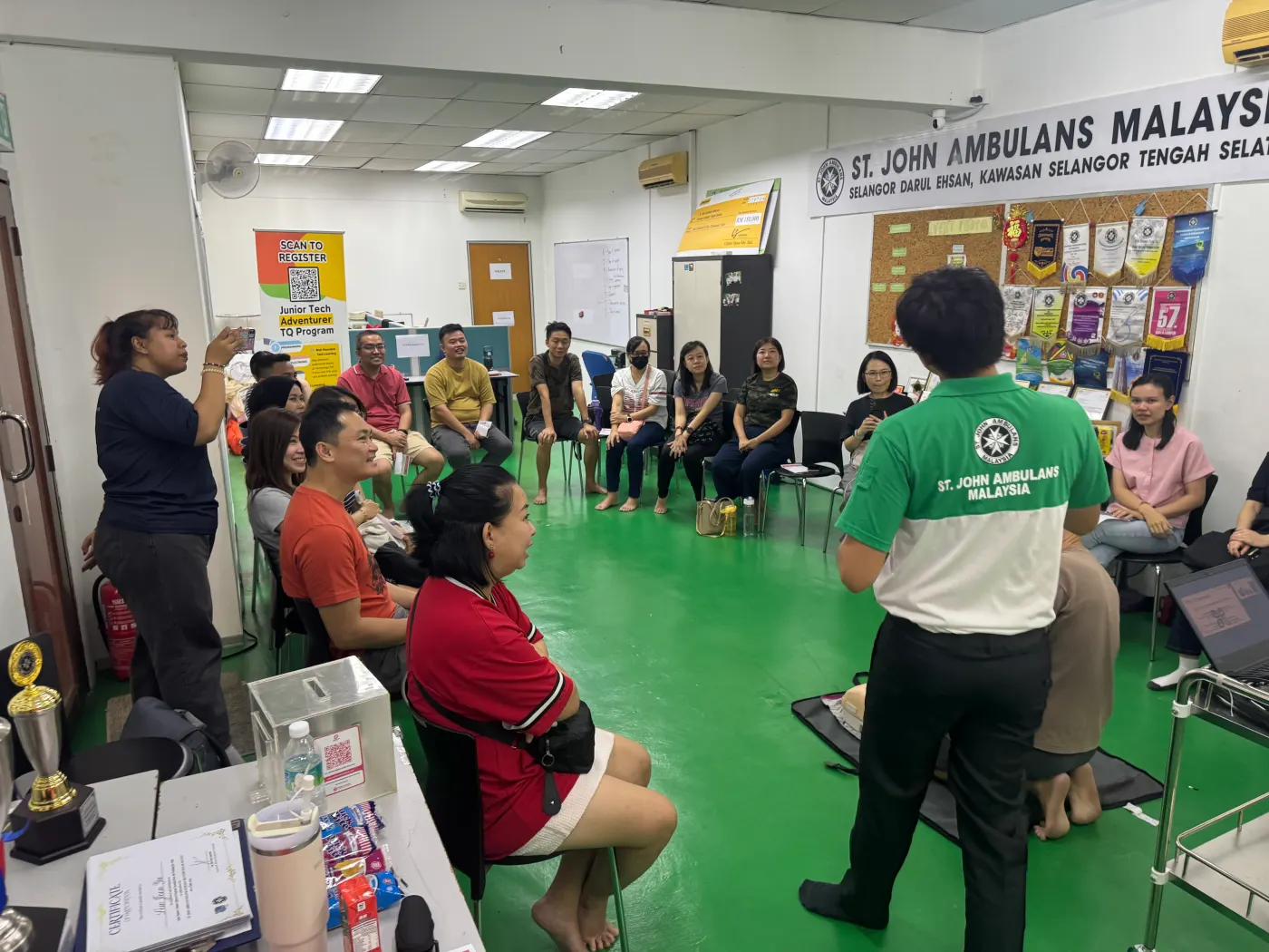 Parents undergoing CPR and AED device training by St John Malaysia trainers.