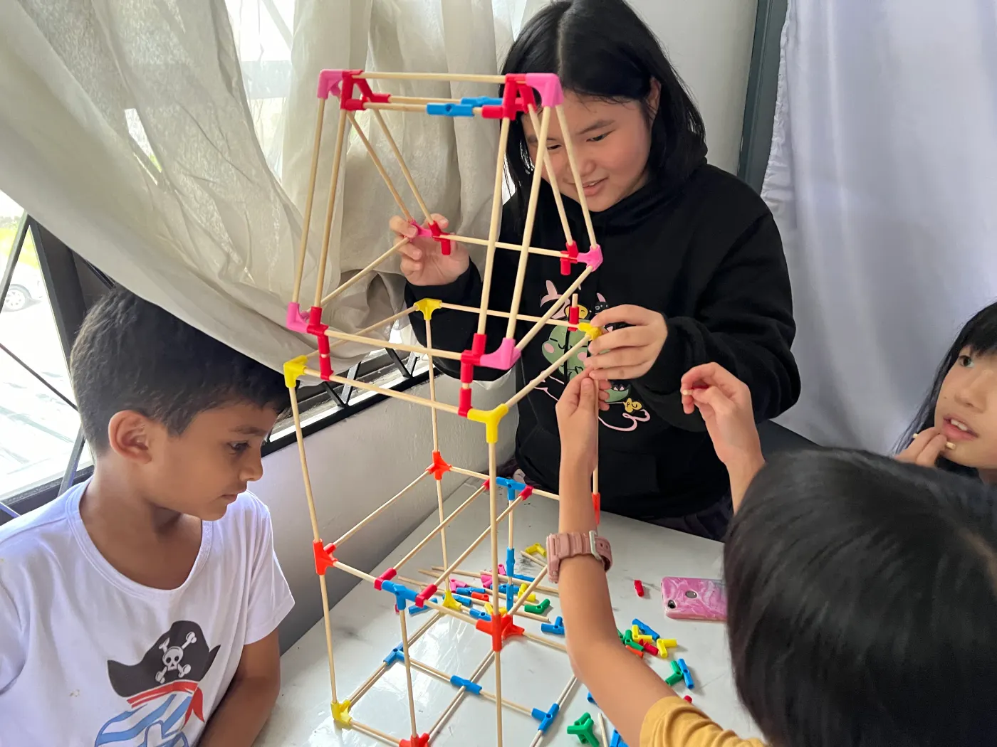 Students and trainer assembling a large rod-and-connector structure