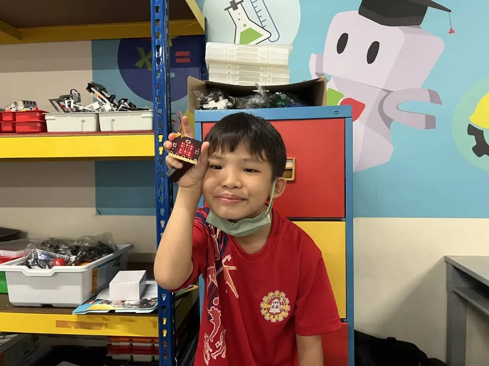 A student in the Agmo Junior classroom with parts shelves behind