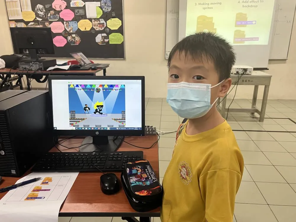 A student beside a Micro:bit console project running on a computer