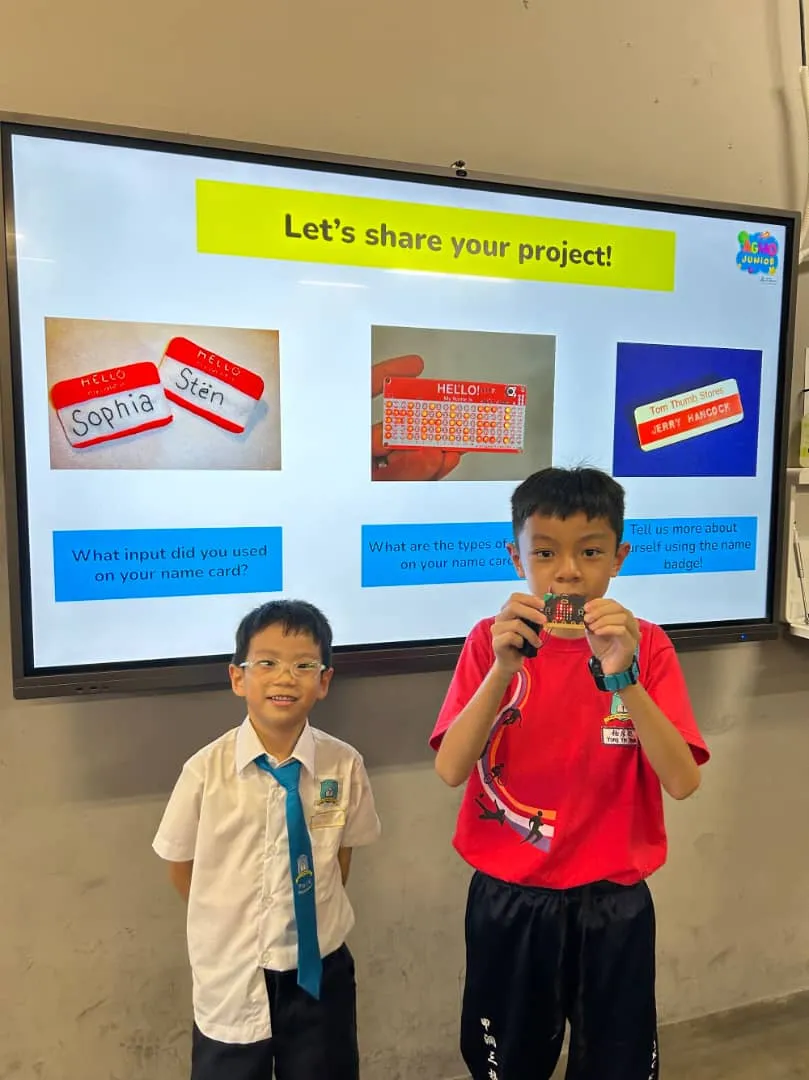 A student standing proudly next to a game he created on Scratch
