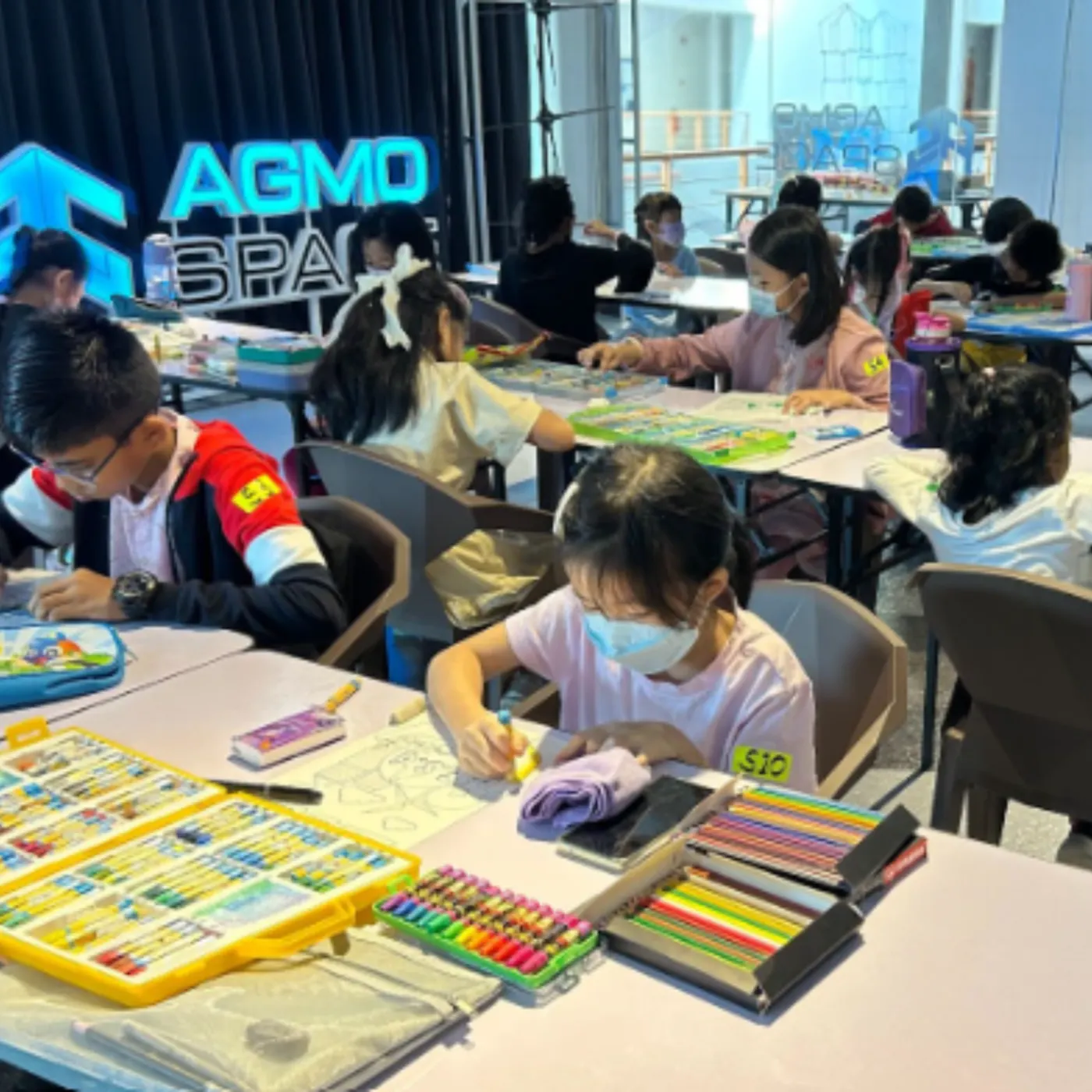 Children working on hands-on craft and electronics projects at a workshop table