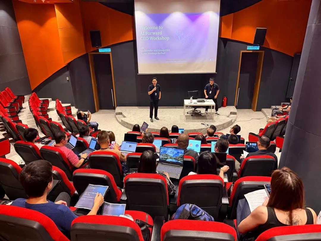 Opening session of the AI Forward CXO Masterclass at Zetrix Tower: two Agmo Academy speakers on stage in front of the Welcome to AI Forward CEO Workshop slide, with participants at laptops in the auditorium